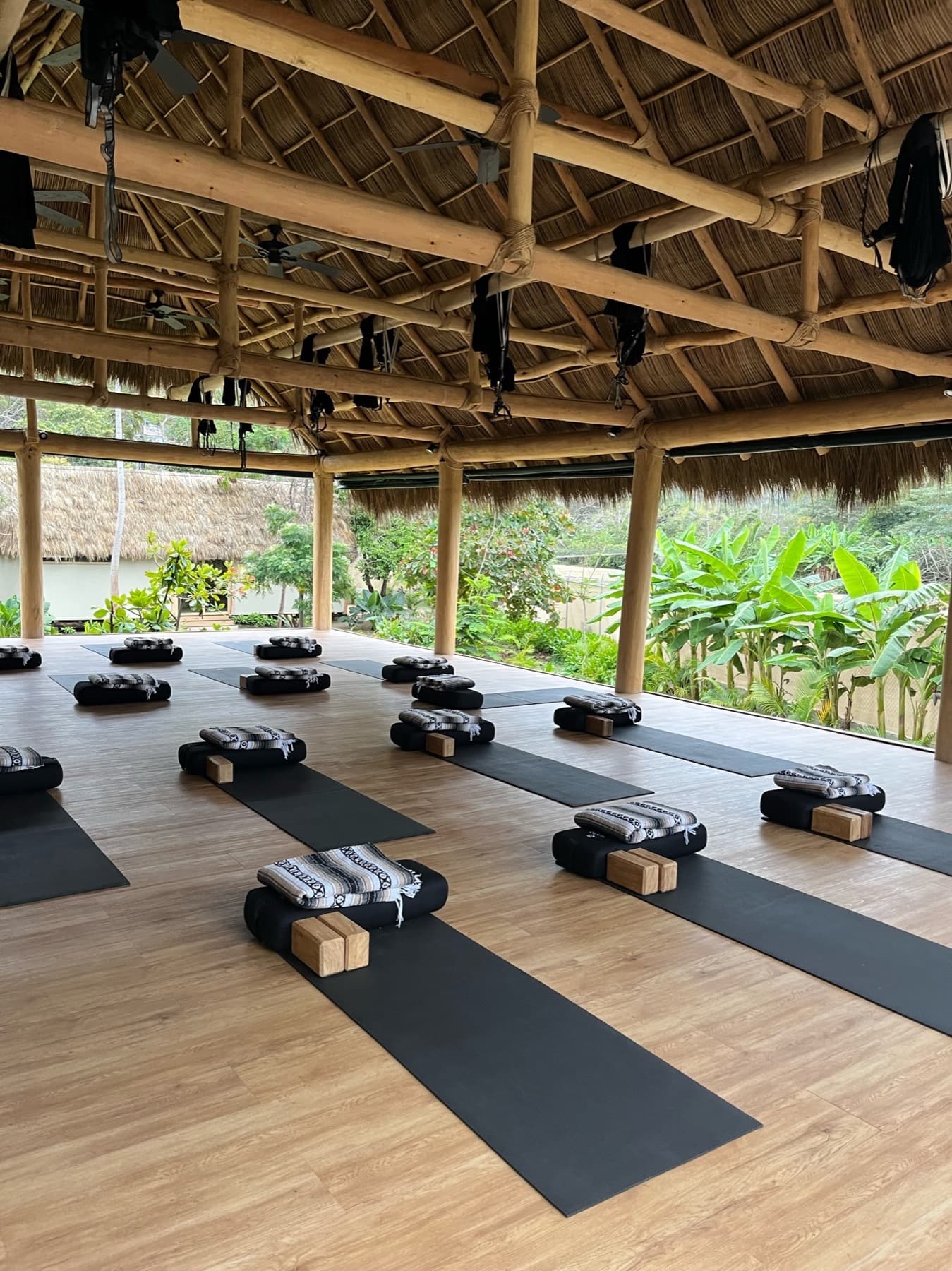 Open-air yoga shala with mats, bolsters, and blocks ready for practice
